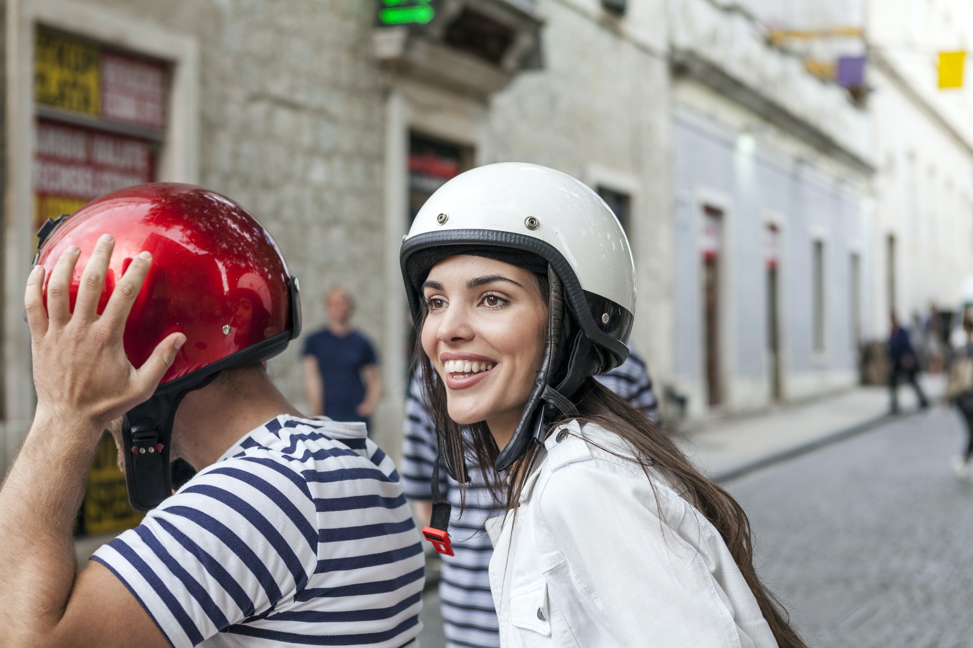 Young couple riding moped through village, Split, Dalmatia, Croatia